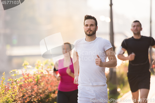 Image of group of young people jogging in the city