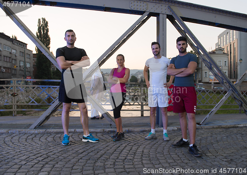 Image of group of young people jogging across the bridge