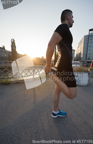 Image of athlete man warming up and stretching