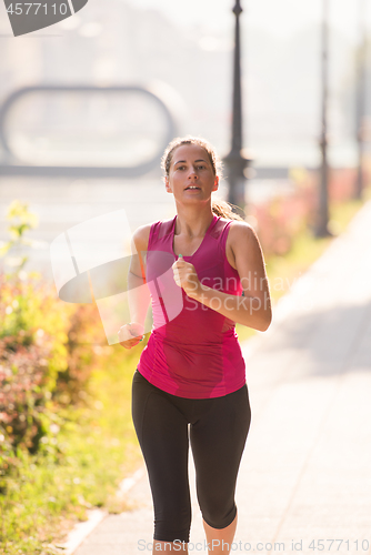 Image of woman jogging at sunny morning