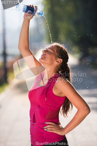 Image of woman pouring water from bottle on her head