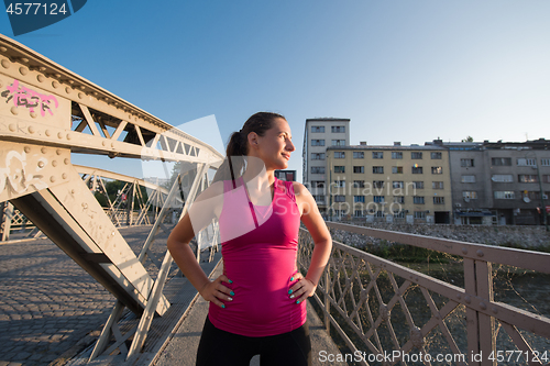 Image of portrait of a jogging woman at sunny morning