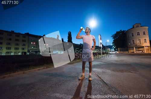 Image of man drinking water after running session