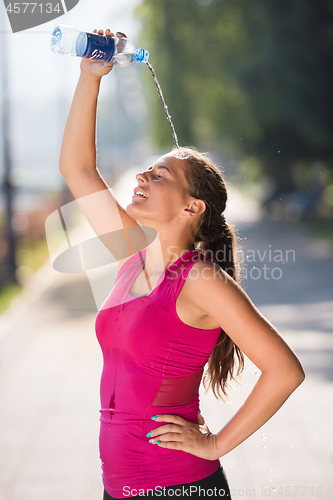 Image of woman pouring water from bottle on her head