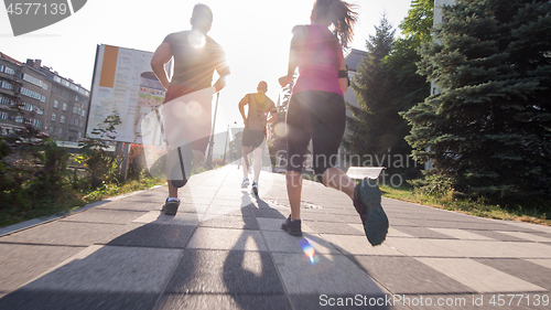 Image of group of young people jogging in the city