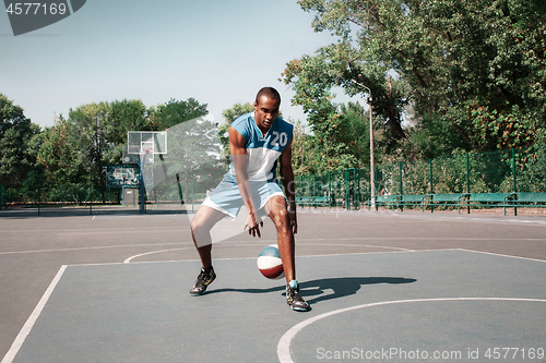 Image of Picture of young confused african basketball player practicing