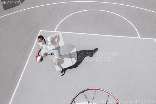 Image of Picture of young confused african basketball player practicing