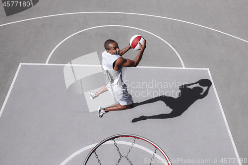 Image of Picture of young confused african basketball player practicing