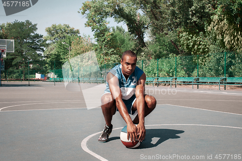 Image of Picture of young confused african basketball player practicing