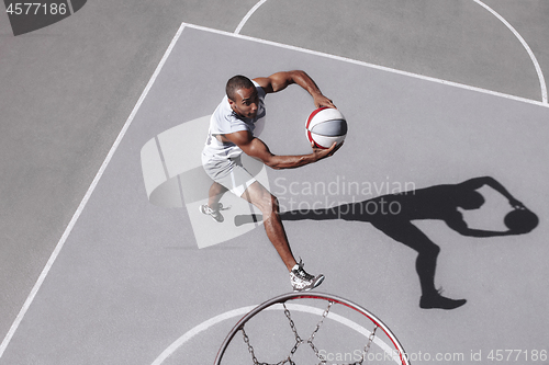 Image of Picture of young confused african basketball player practicing