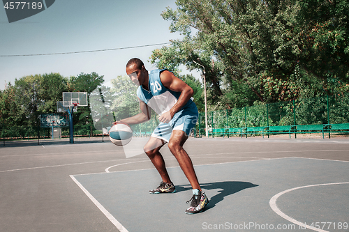 Image of Picture of young confused african basketball player practicing