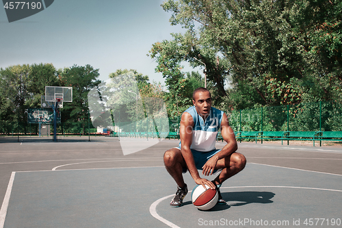 Image of Picture of young confused african basketball player practicing