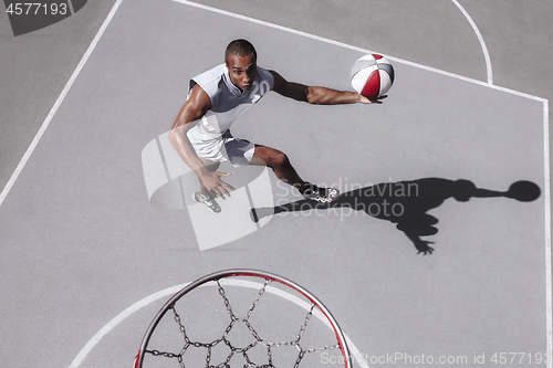 Image of Picture of young confused african basketball player practicing