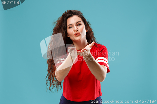 Image of The happy business woman standing and smiling against blue background.