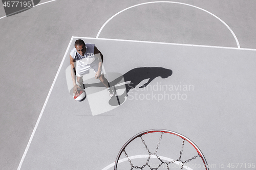 Image of Picture of young confused african basketball player practicing