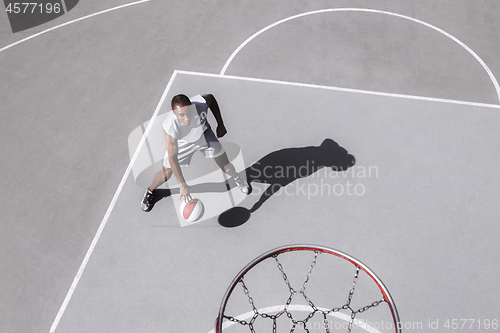 Image of Picture of young confused african basketball player practicing