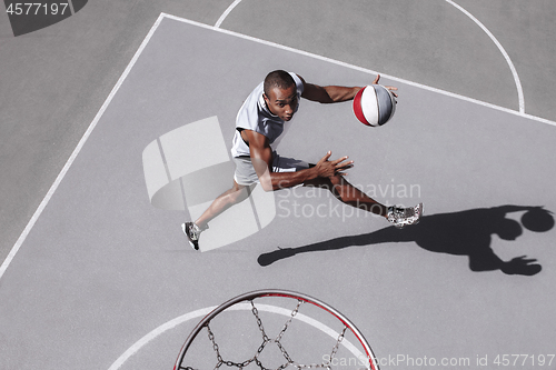 Image of Picture of young confused african basketball player practicing