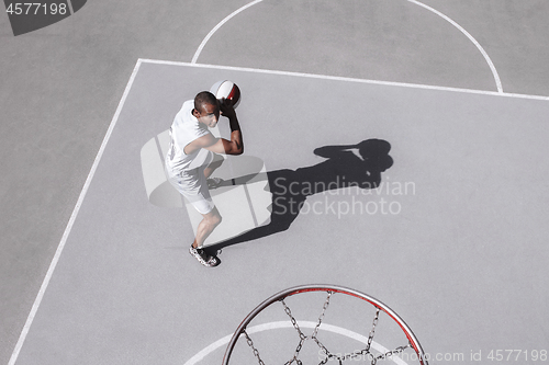 Image of Picture of young confused african basketball player practicing