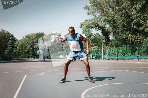 Image of Picture of young confused african basketball player practicing