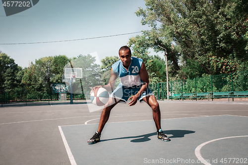 Image of Picture of young confused african basketball player practicing