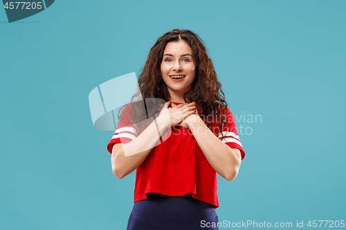 Image of The happy business woman standing and smiling against blue background.