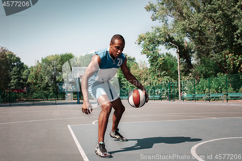 Image of Picture of young confused african basketball player practicing