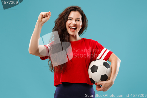 Image of Fan sport woman player holding soccer ball isolated on blue background