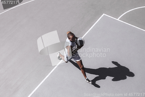 Image of Picture of young confused african basketball player practicing