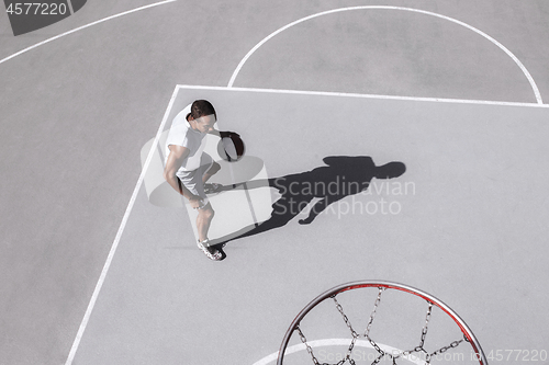 Image of Picture of young confused african basketball player practicing