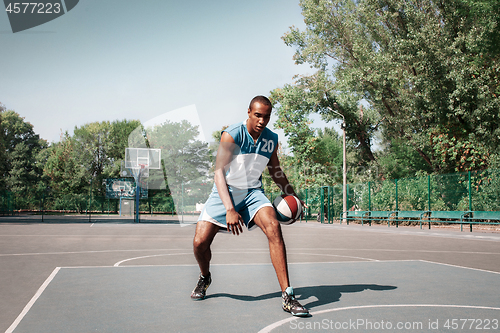 Image of Picture of young confused african basketball player practicing