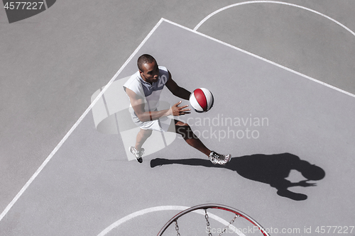 Image of Picture of young confused african basketball player practicing