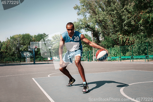 Image of Picture of young confused african basketball player practicing