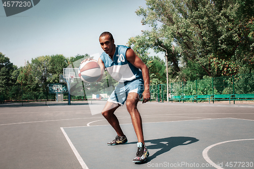 Image of Picture of young confused african basketball player practicing