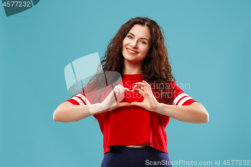 Image of The happy business woman standing and smiling against blue background.