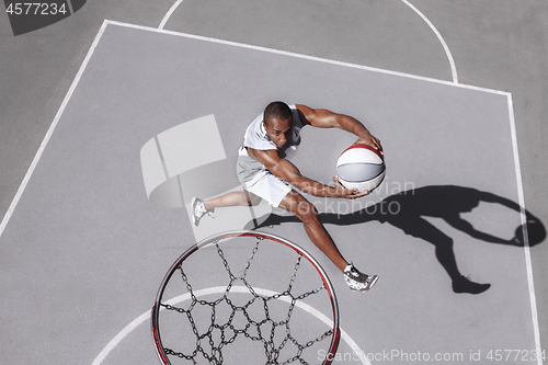 Image of Picture of young confused african basketball player practicing