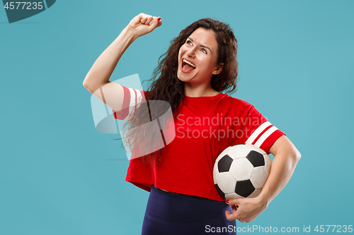 Image of Fan sport woman player holding soccer ball isolated on blue background