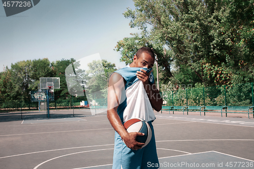 Image of Picture of young confused african basketball player practicing