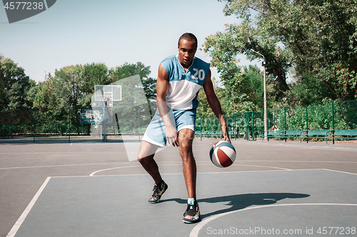 Image of Picture of young confused african basketball player practicing