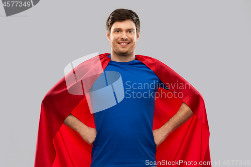 Image of man in red superhero cape over grey background