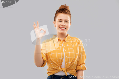 Image of happy red haired teenage girl showing ok hand sign