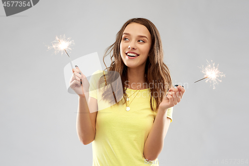 Image of happy teenage girl with two sparklers