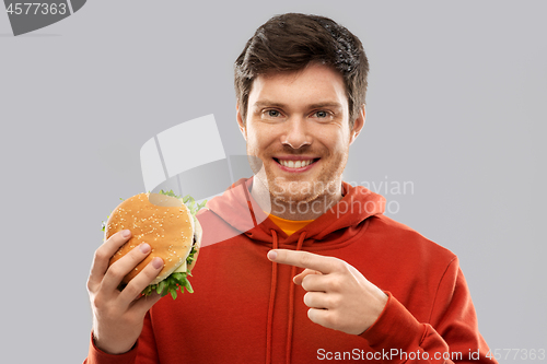 Image of happy young man showing hamburger