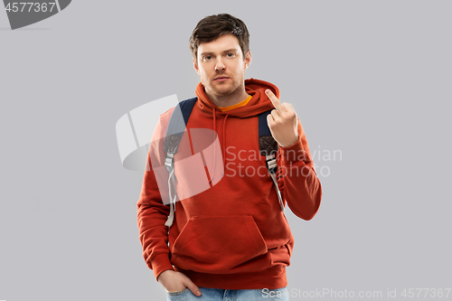 Image of male student with school bag showing middle finger