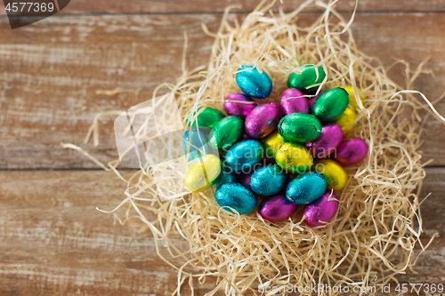 Image of chocolate eggs in foil wrappers in straw nest