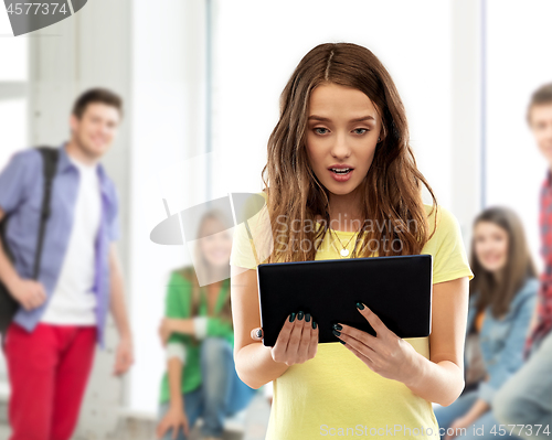 Image of shocked student girl with tablet pc at school