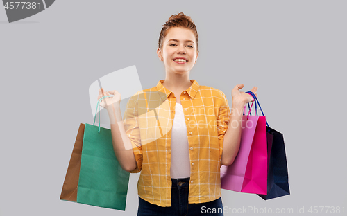 Image of smiling red haired teenage girl with shopping bags