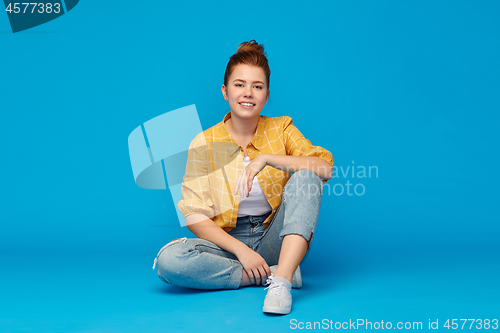 Image of red haired teenage girl in shirt and torn jeans