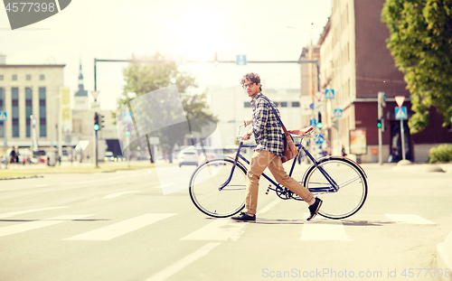 Image of young man with fixed gear bicycle on crosswalk