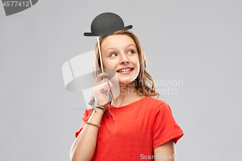 Image of smiling teenage girl with bowler hat party prop