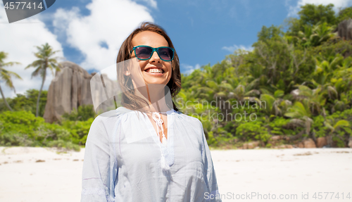 Image of happy smiling woman in sunglasses over beach